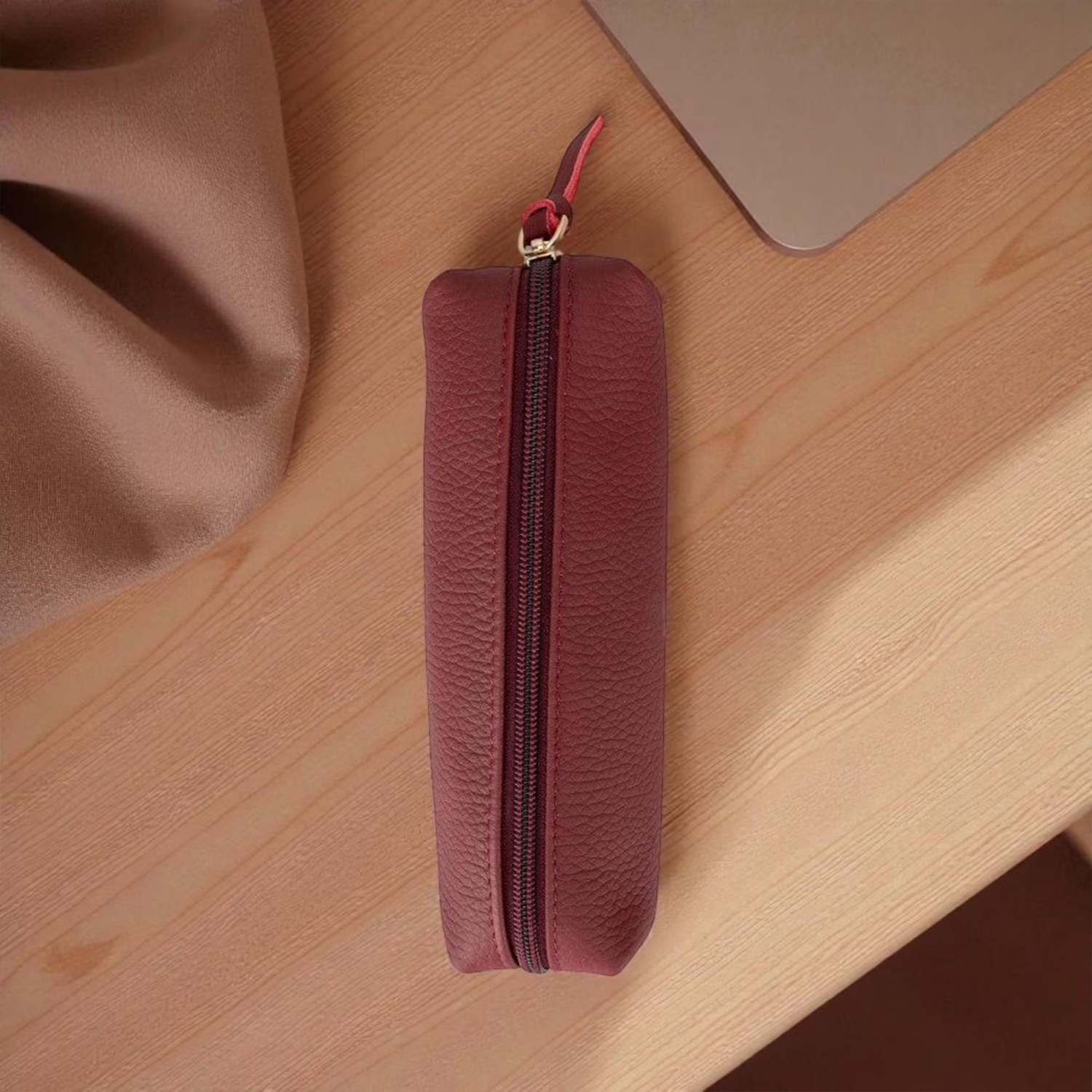 Burgundy Pebbled Textured Elongated Stationery Pouch With Full-Length Gold-Tone Zip Closure, Fabric Pull Tab And Folded Rounded End Cap Silhouette