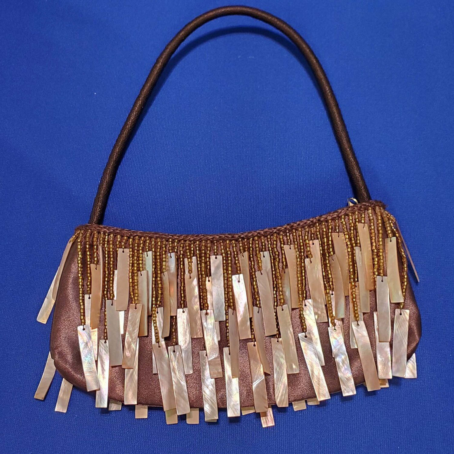 Warm Brown Glossy Silk Curved Shoulder Pouch With Layered Golden Seed Bead & Polished Seashell Slab Fringe Trim And Wrapped Fabric Single Shoulder Strap